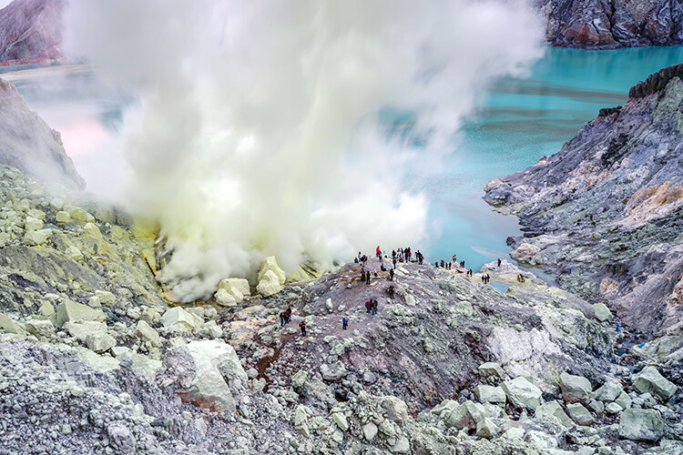 Sulfur burned by blue flame in the crater blue lake at Kawah Ijen, Indonesia