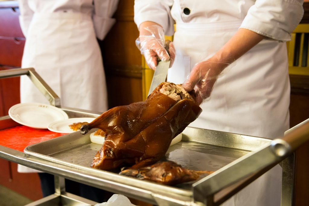 Chef is cutting the famous Peking roasted duck
