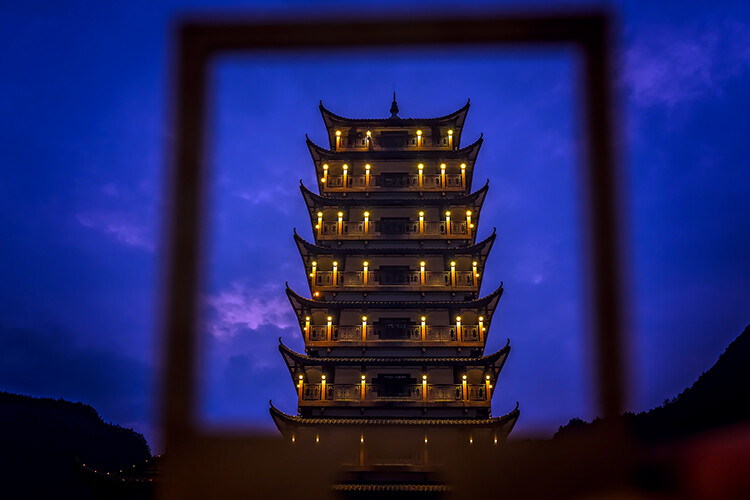 Photographed at dusk traditional chinese style wooden tower pagoda seen through the frame, Wulingyuan entrance to the Zhangjiajie national park, Hunan Province, China
