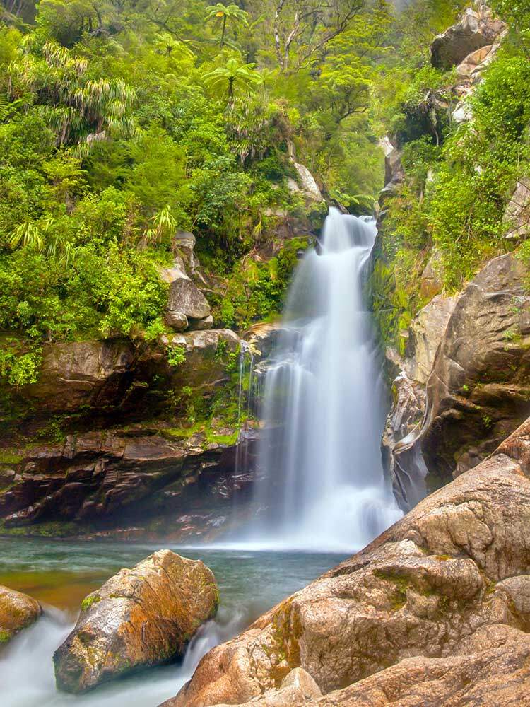Aliran Sungai yang segar di Air Terjun Wanui di Pergunungan Abel Tasman National Park, Pulau Selatan