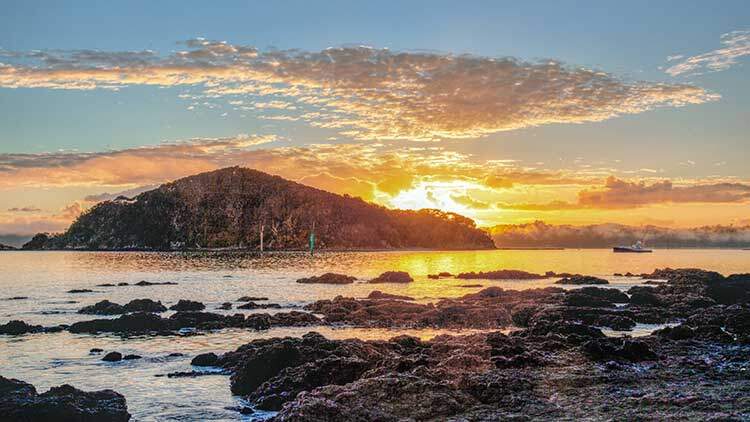 Matahari terbit di Teluk Kepulauan, sebuah kawasan di pantai timur Daerah Jauh Utara Pulau Utara New Zealand. Ia adalah salah satu destinasi memancing, pelayaran dan pelancongan yang paling popular di negara ini